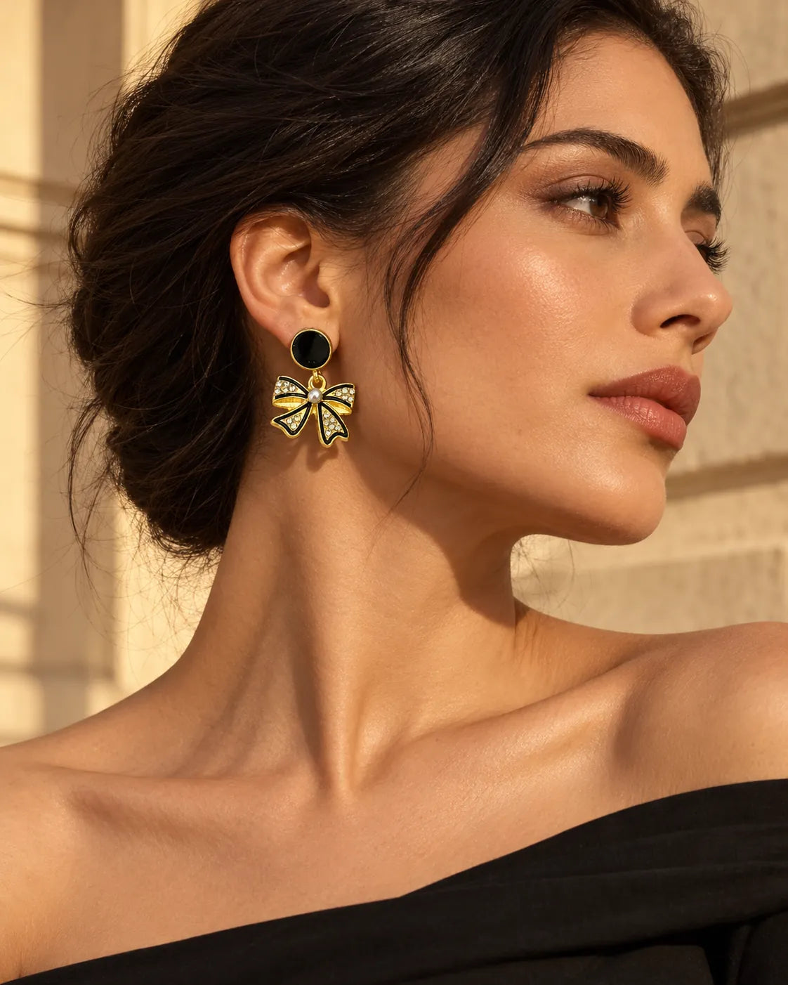 Model in an off-shoulder black top wearing the black bow earrings