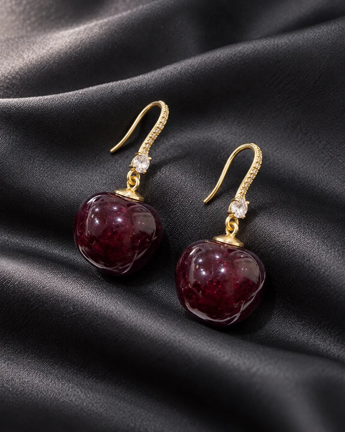 Burgundy-red cherry drop earrings with crystal hooks on black satin