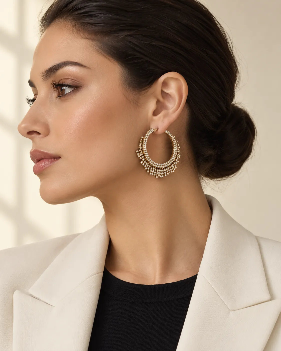 Side profile of a model with a bun wearing the gold crystal fringe hoops