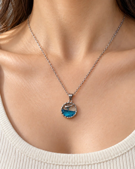 Model wearing the Delphine ocean blue dolphin pendant necklace at the collarbone