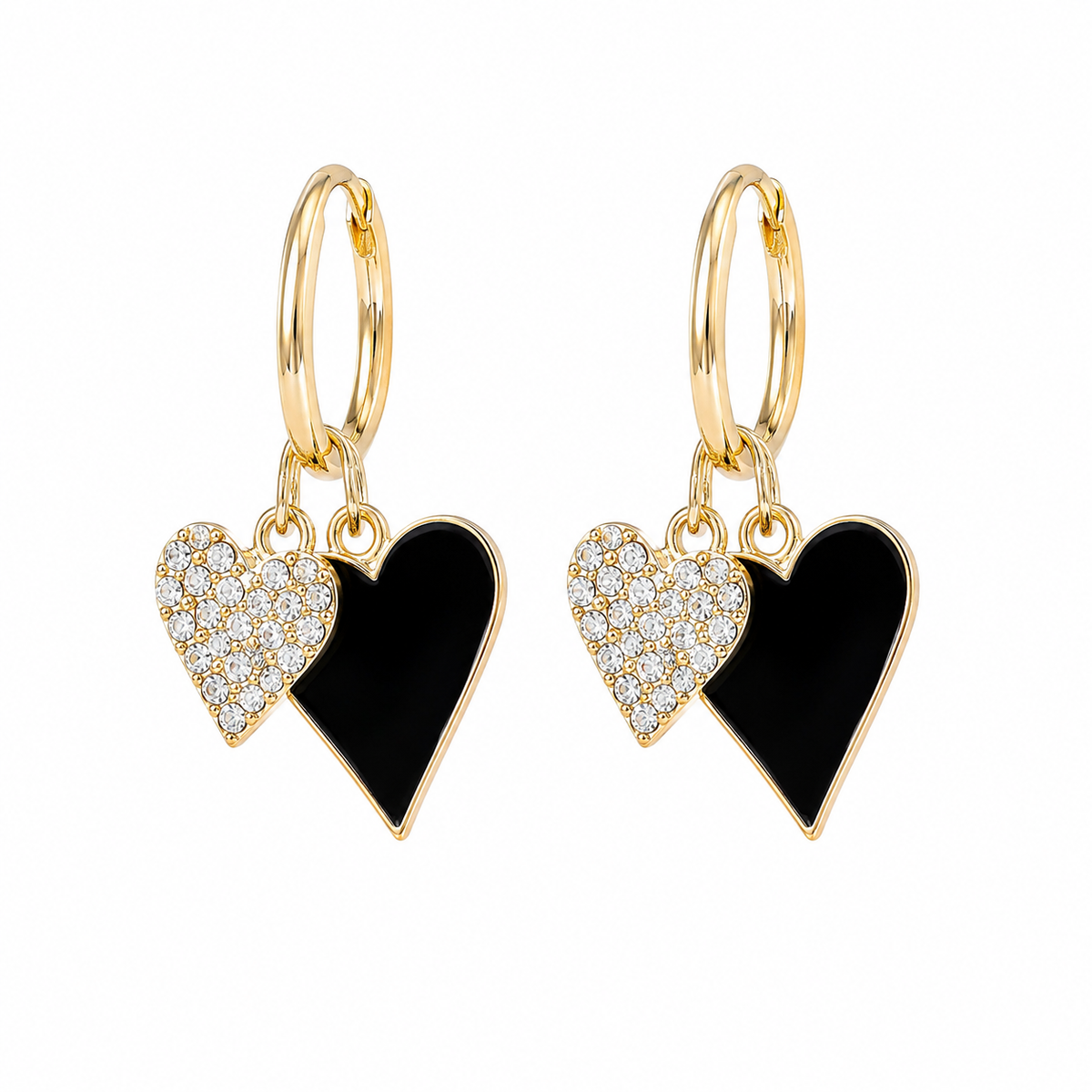 A pair of gold hoop drop earrings featuring two heart charms: one with a black enamel center and one with a pavé crystal-encrusted center, set against a plain white background.