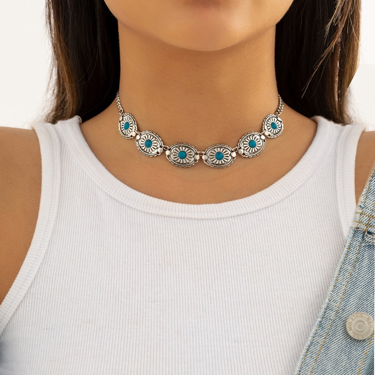 Necklace with blue and green accents worn by a person in a white tank top.