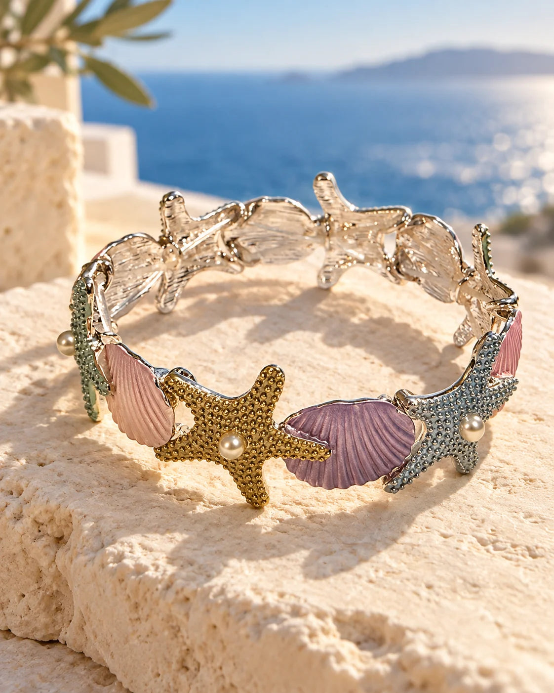 Pastel starfish and shell bracelet on sandstone with an ocean view
