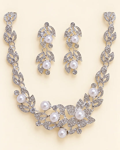 Ivy silver leaf and pearl bridal jewellery set laid flat on cream, showing the leaf vine necklace and matching pearl drop earrings