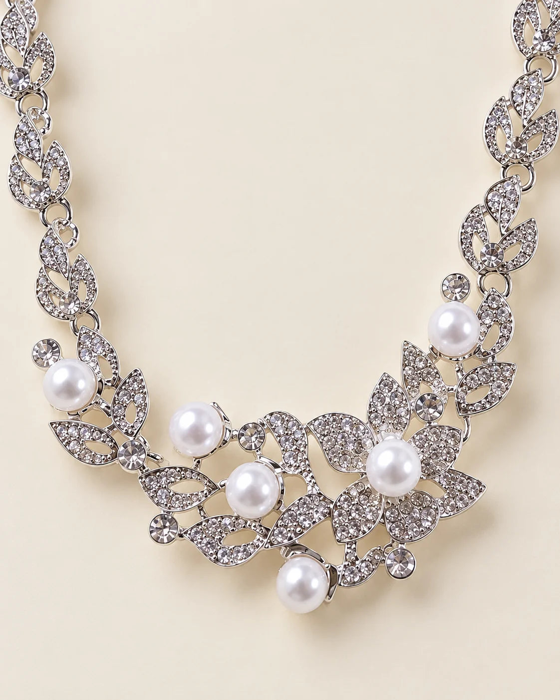 Close-up of the Ivy necklace centrepiece with rhinestone-set silver leaves and pearl-look beads