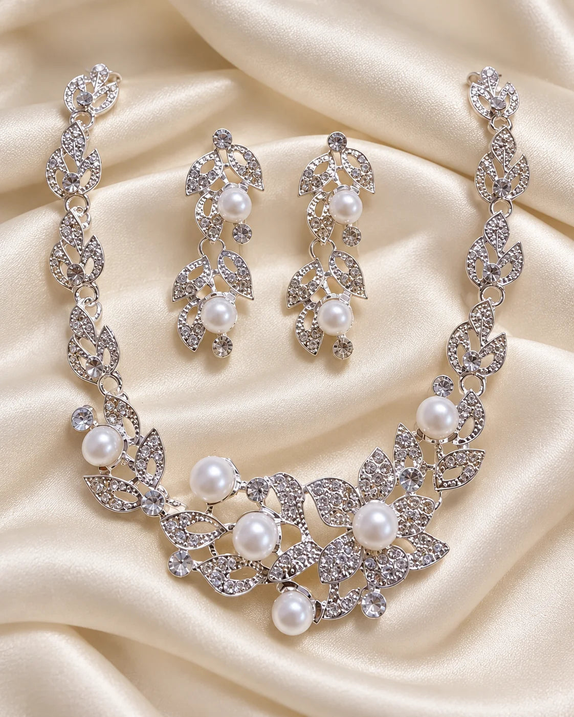 Ivy silver leaf and pearl jewellery set arranged on ivory satin