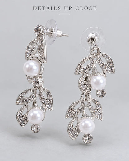 Close-up of the silver leaf and pearl drop earrings showing the post back and crystal stud tops