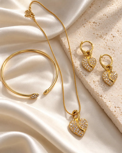 Gold pavé heart necklace, earrings and bangle set on ivory satin