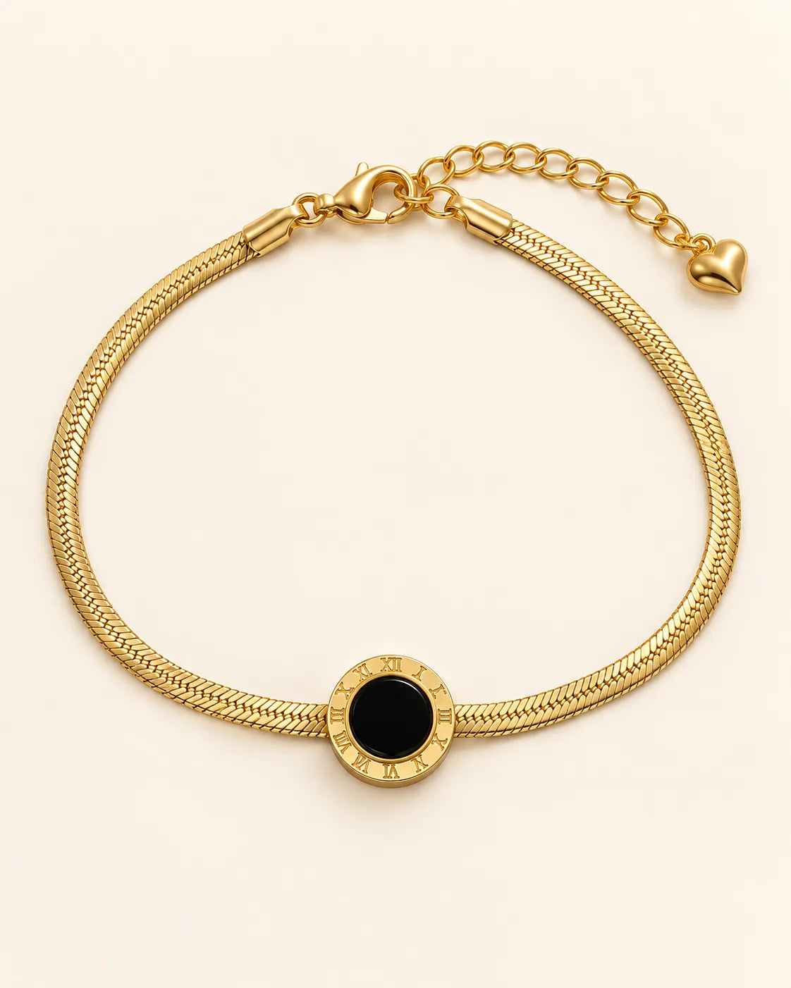Gold herringbone bracelet with Roman numeral black disc on a cream background