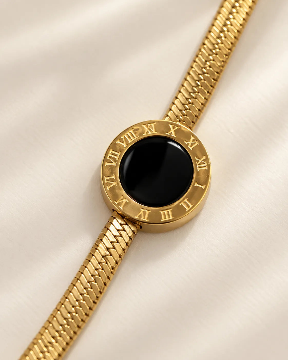 Close-up of the Roman numeral gold disc with glossy black enamel centre