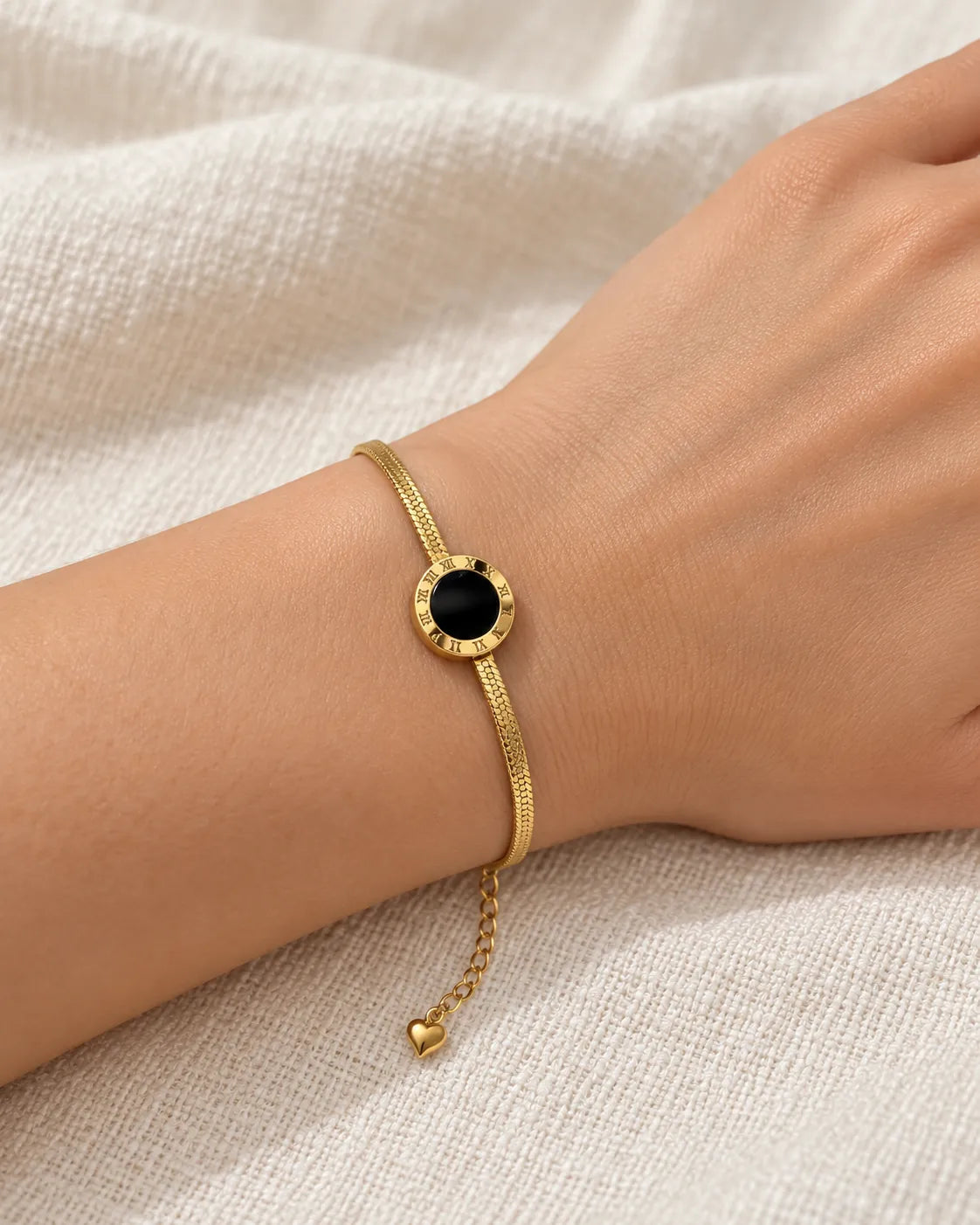 Wrist wearing the gold and black Roman numeral disc bracelet