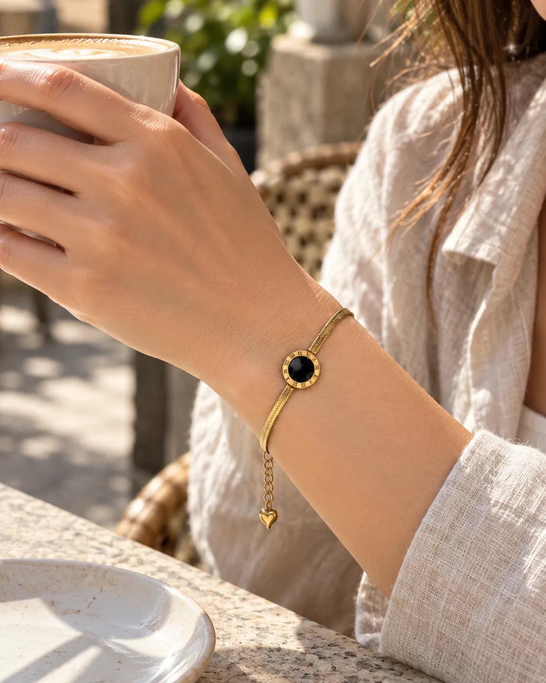 Wrist holding a coffee cup wearing the black disc herringbone bracelet