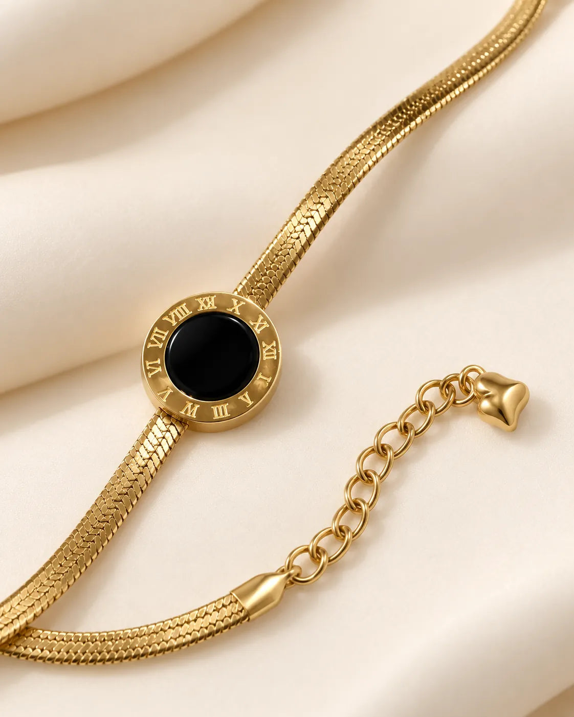 Angled close-up of the black disc and flat gold herringbone chain