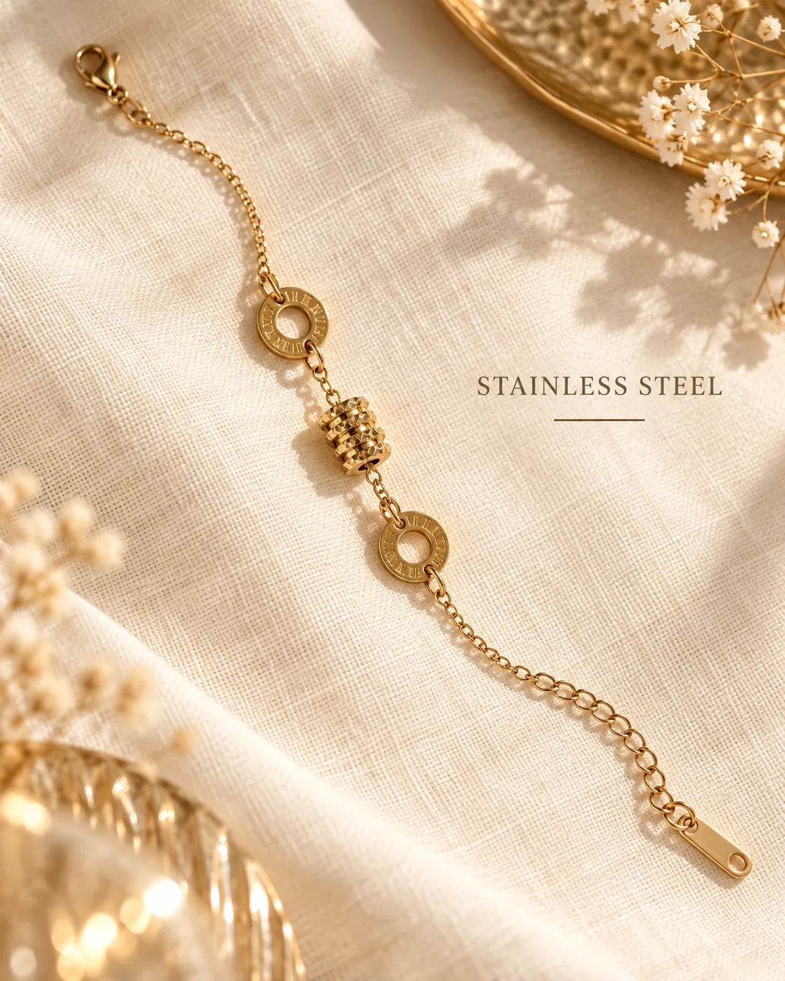 Gold drum charm chain bracelet laid on linen