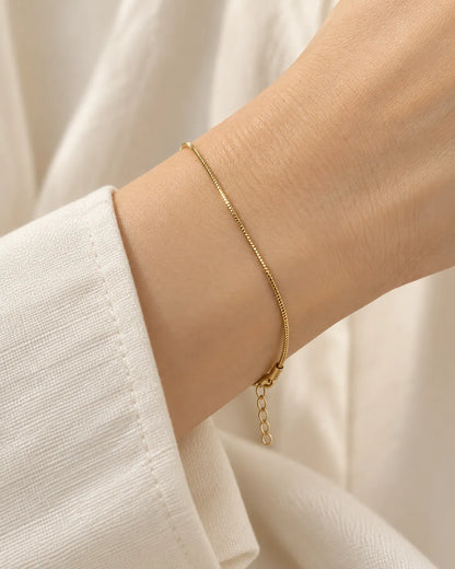 Wrist wearing the thin gold snake chain bracelet