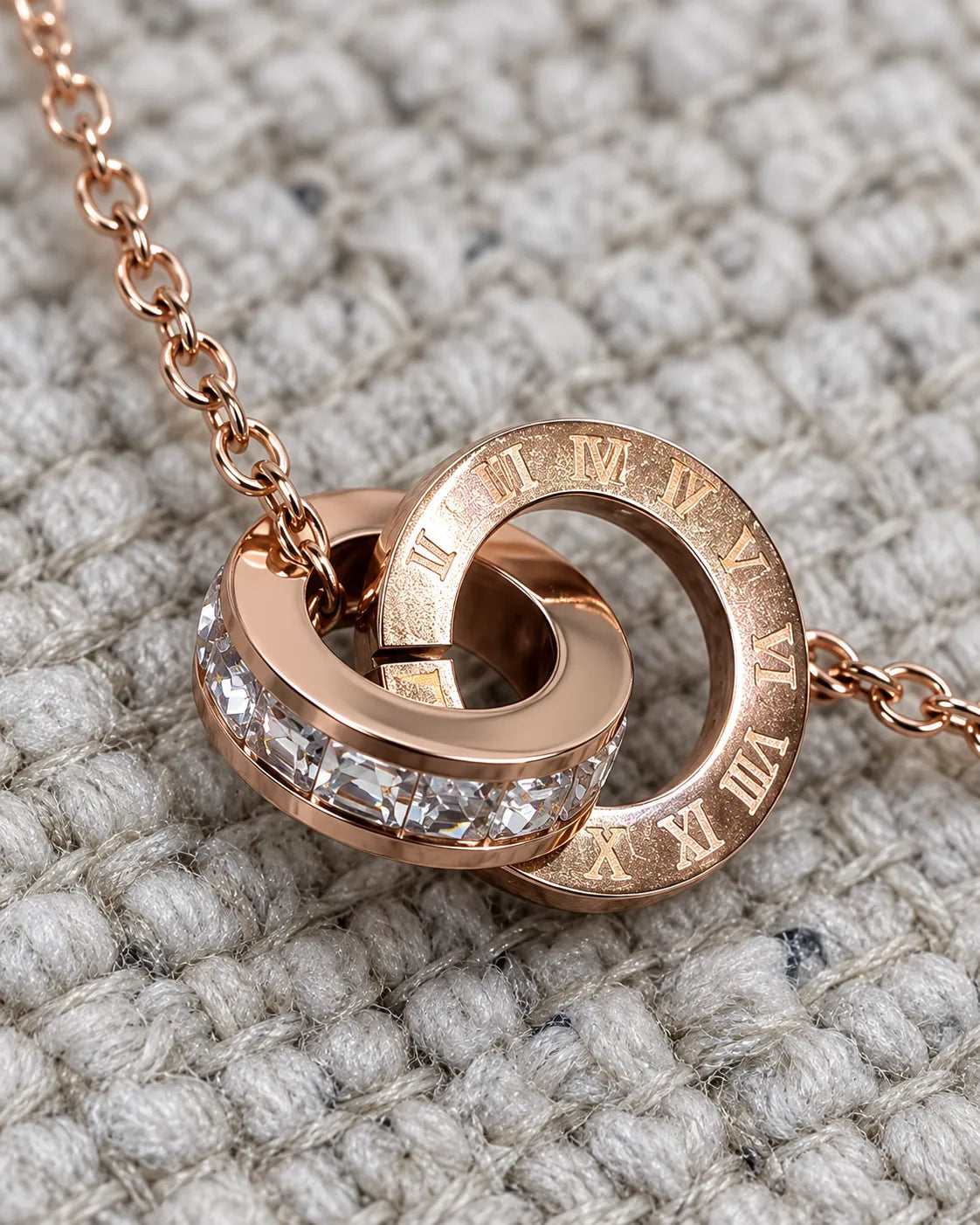 Close-up of the engraved ring and clear crystal ring on a knitted texture
