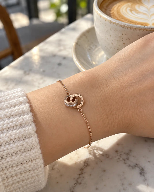 Wrist beside a coffee cup wearing the rose gold circles bracelet