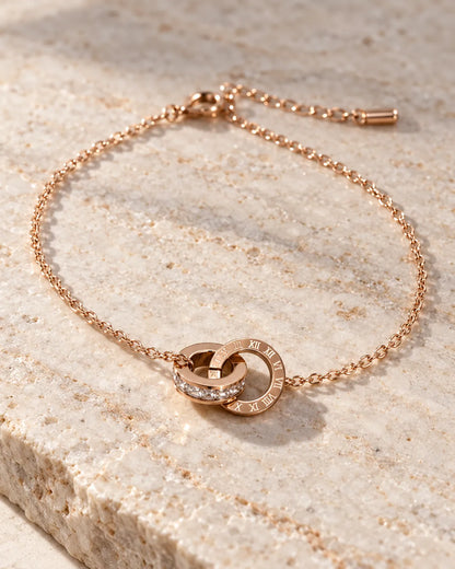 Rose gold interlocking circles bracelet on a stone slab