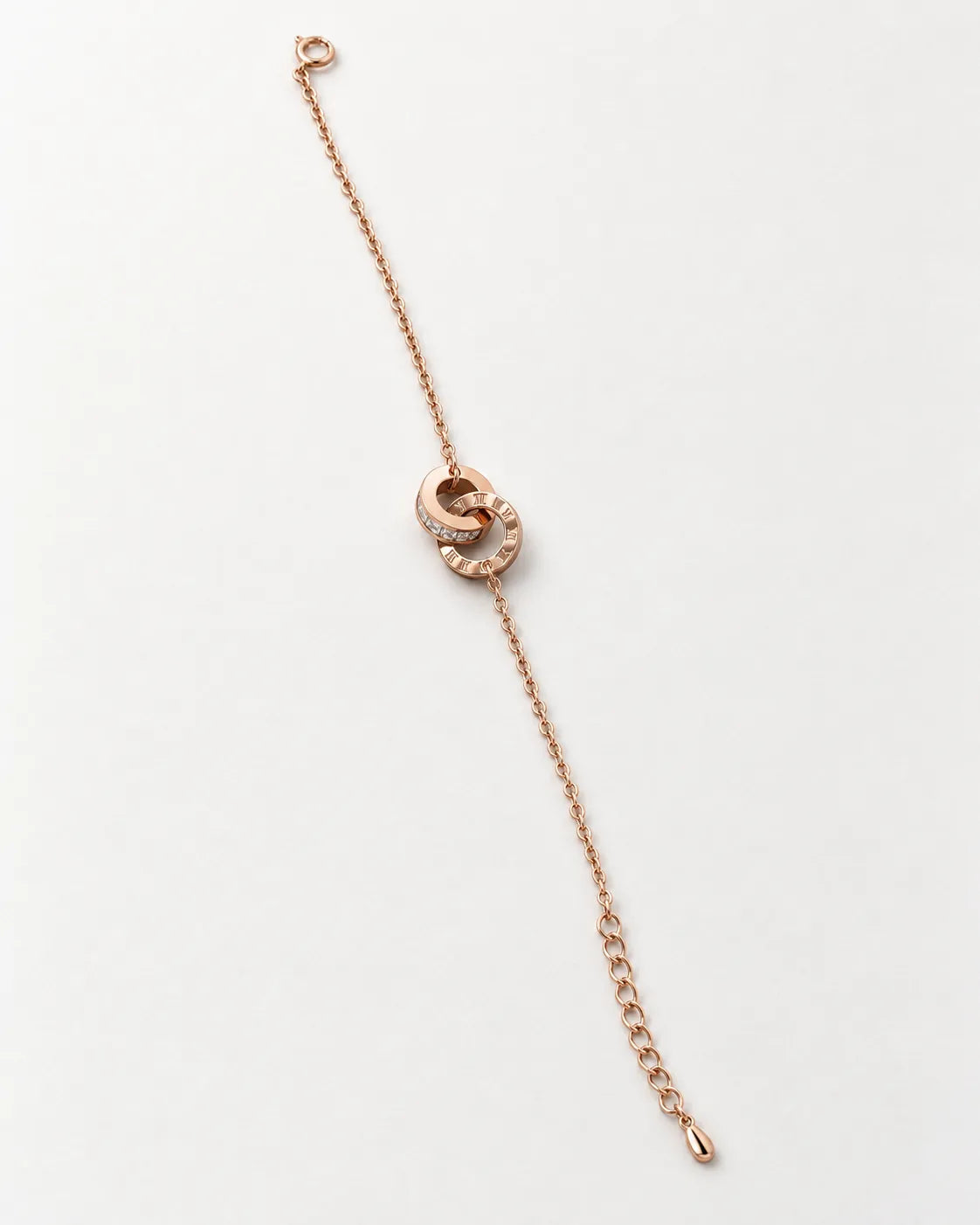 Rose gold interlocking rings bracelet laid straight on white