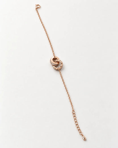 Rose gold interlocking rings bracelet laid straight on white