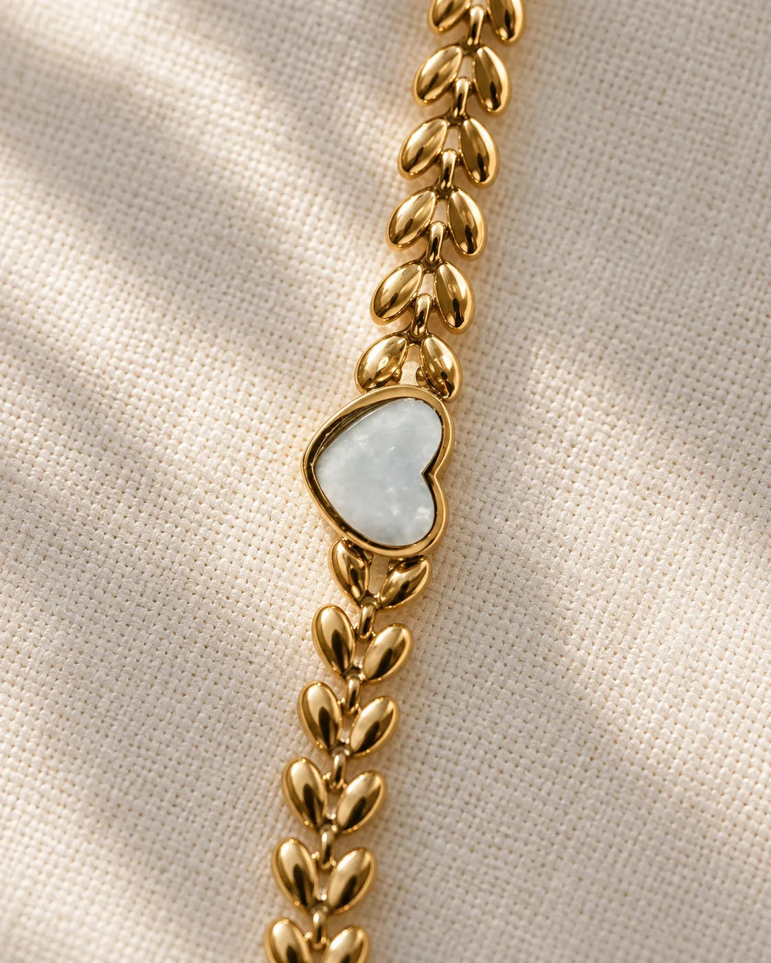 Detail of the white heart and gold leaf links on linen