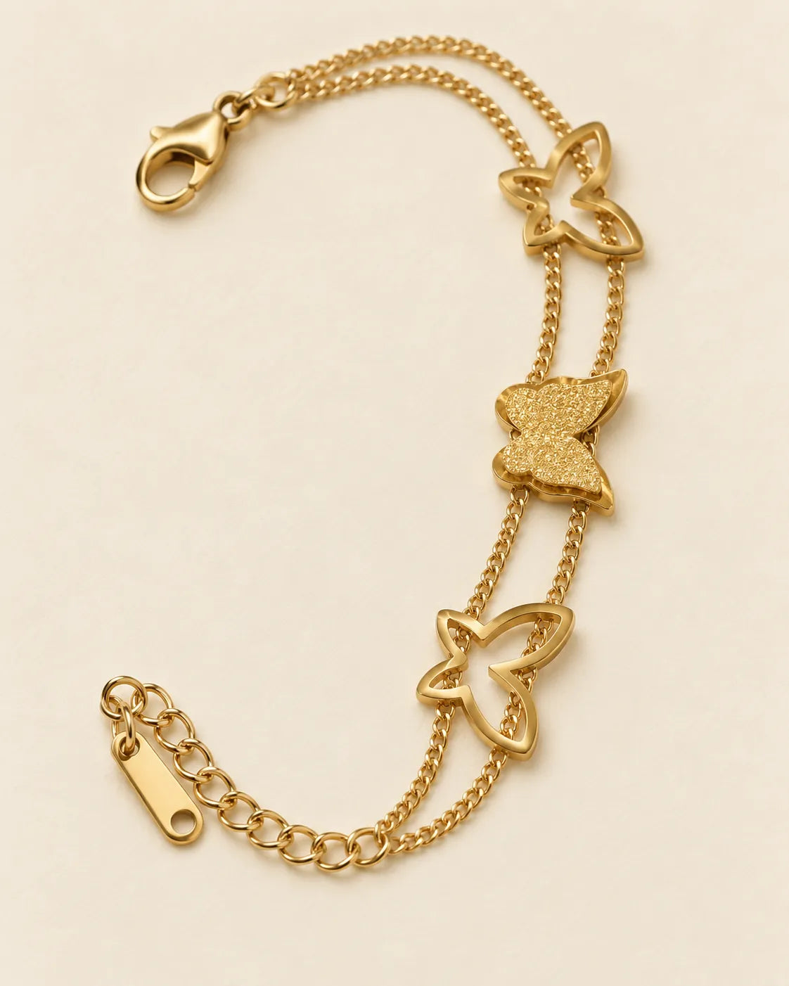 Gold butterfly bracelet on cream showing the lobster clasp