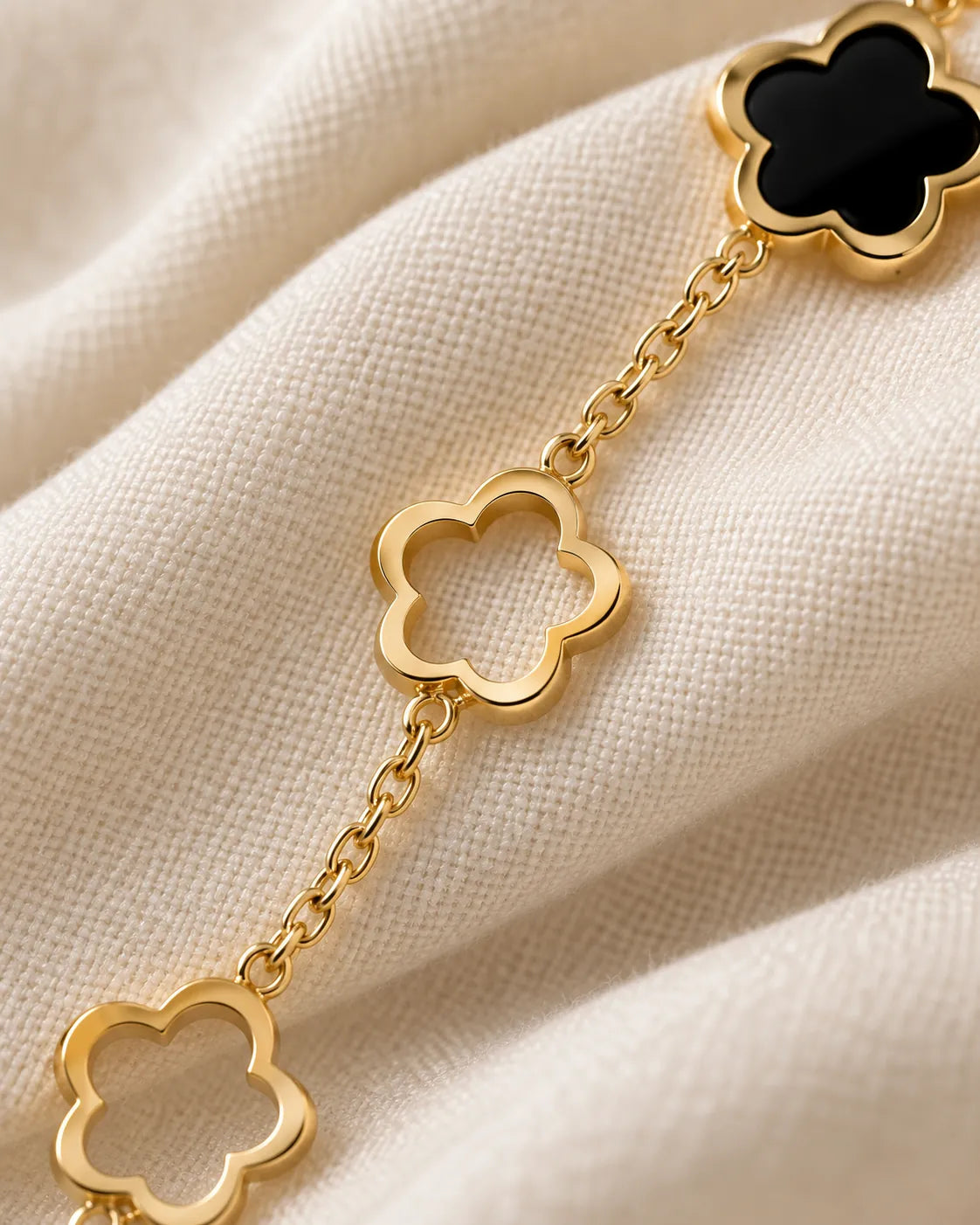 Close-up of the open gold flower-outline links and black clover