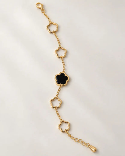 Gold and black clover chain bracelet laid straight on a white background