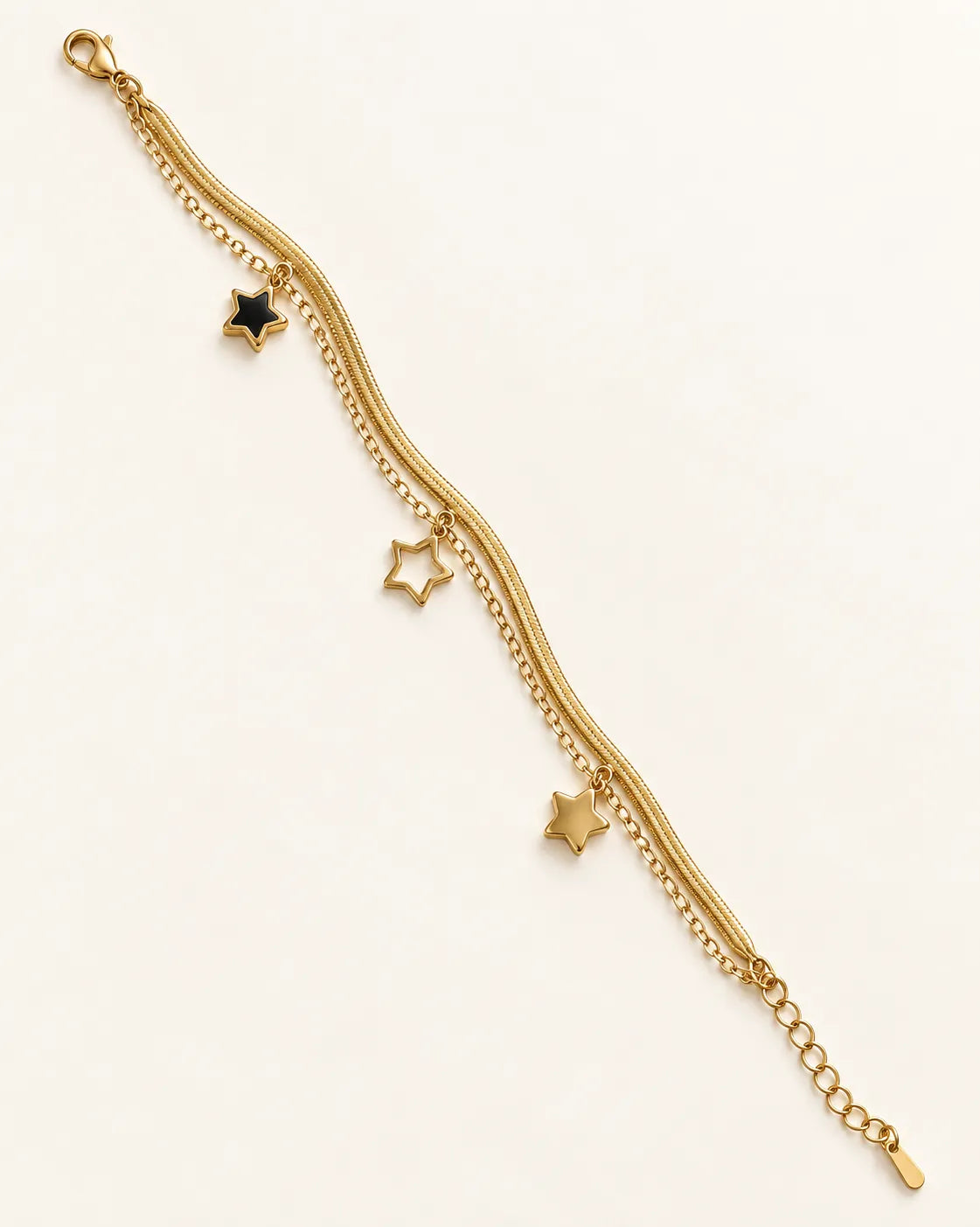 Two-strand gold star charm bracelet laid straight on a white background