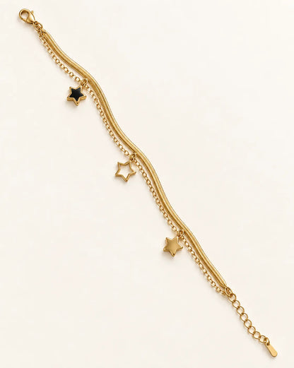 Two-strand gold star charm bracelet laid straight on a white background