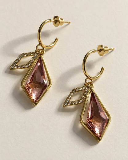 Rhombus pink crystal drop earrings with gold-tone half-hoops on a cream background