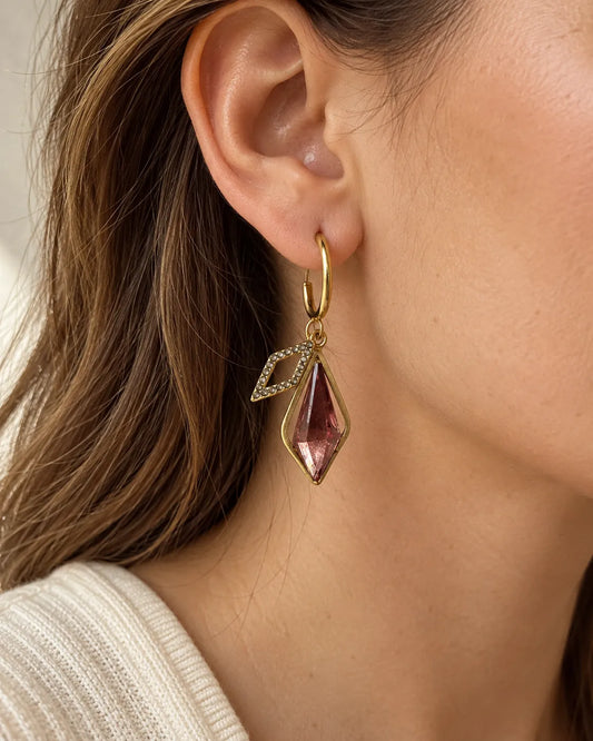 Close-up of a model's ear wearing the gold and pink crystal drop earring