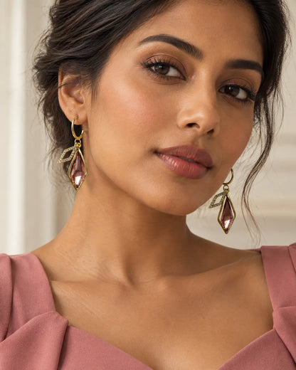 Model in a pink top wearing the gold-tone rhombus pink crystal earrings