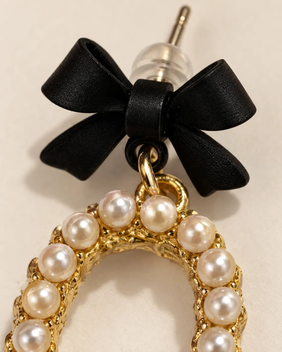 Close-up of the matte black bow, clear backing and pearl-look beaded oval