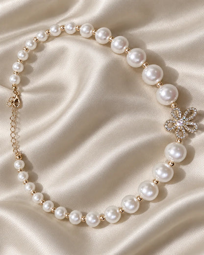 Gold flower pearl-look bead necklace on champagne satin