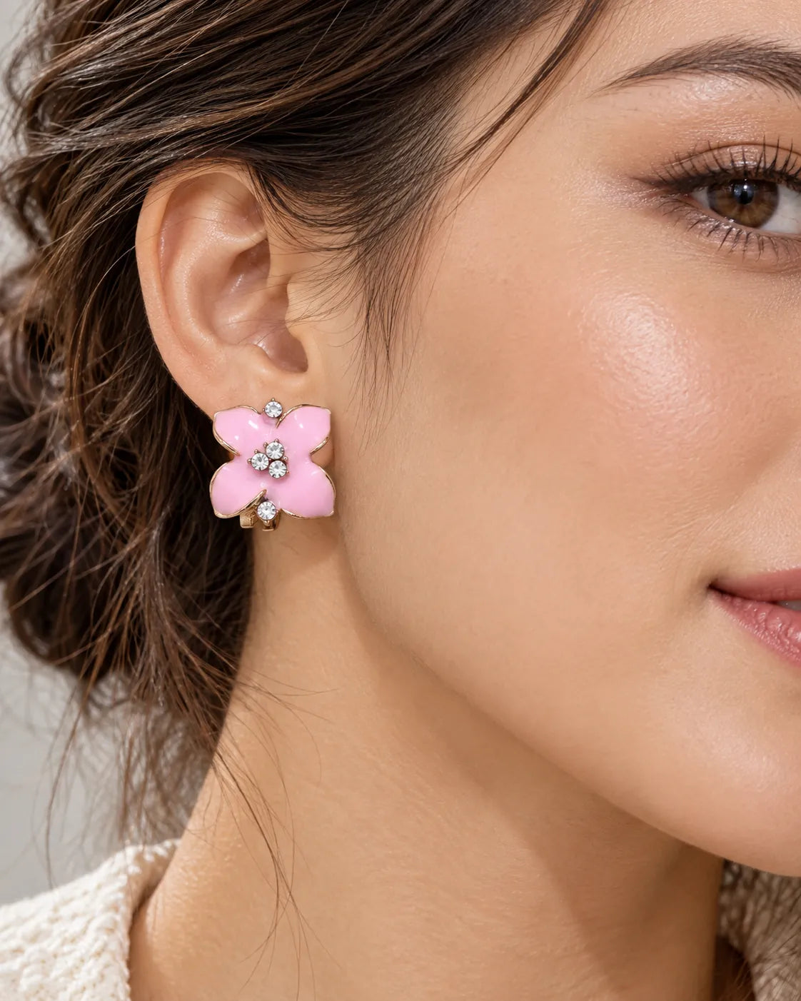 Close-up of the pink camellia flower stud worn on the ear