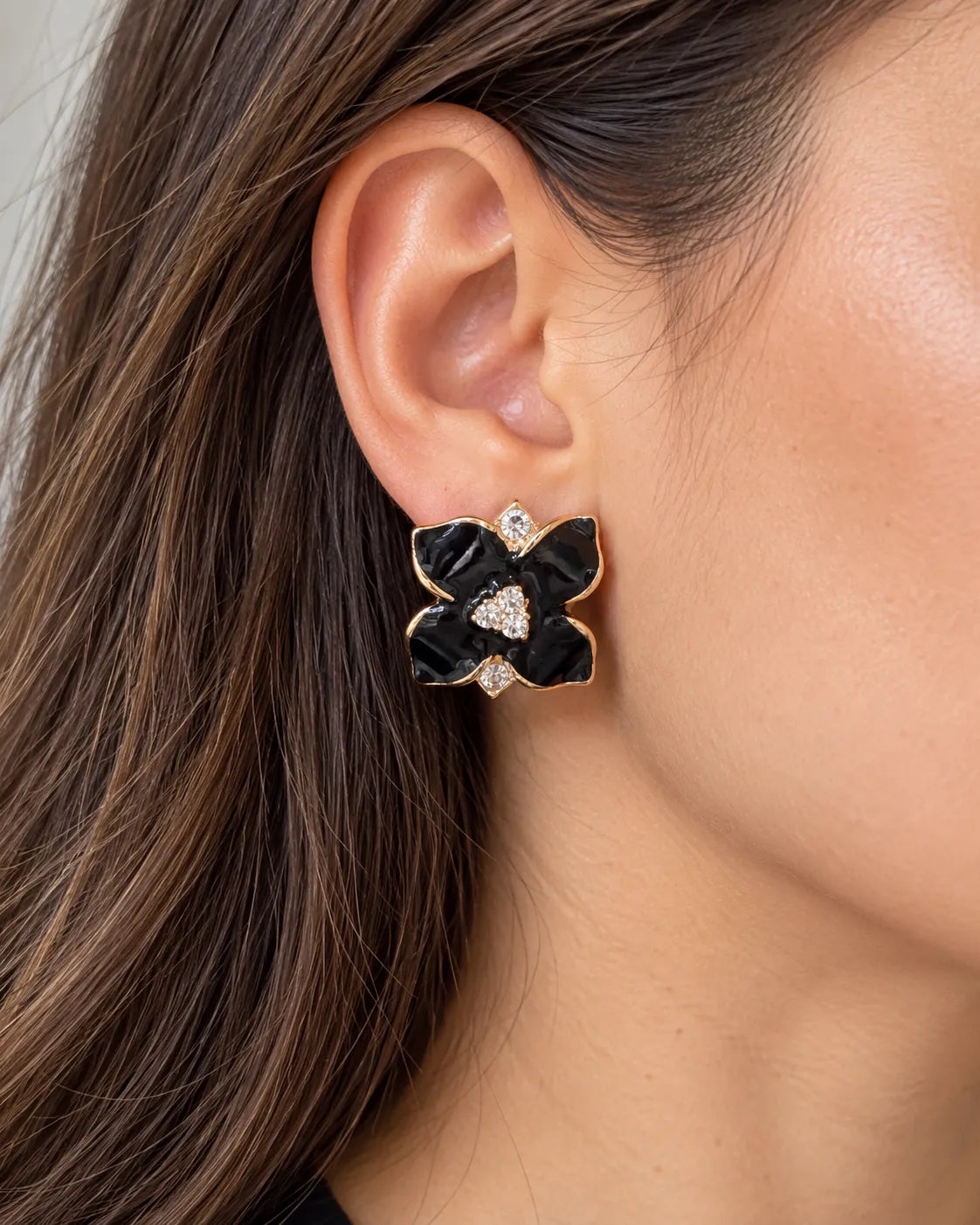 Close-up of the black camellia flower stud worn on the ear