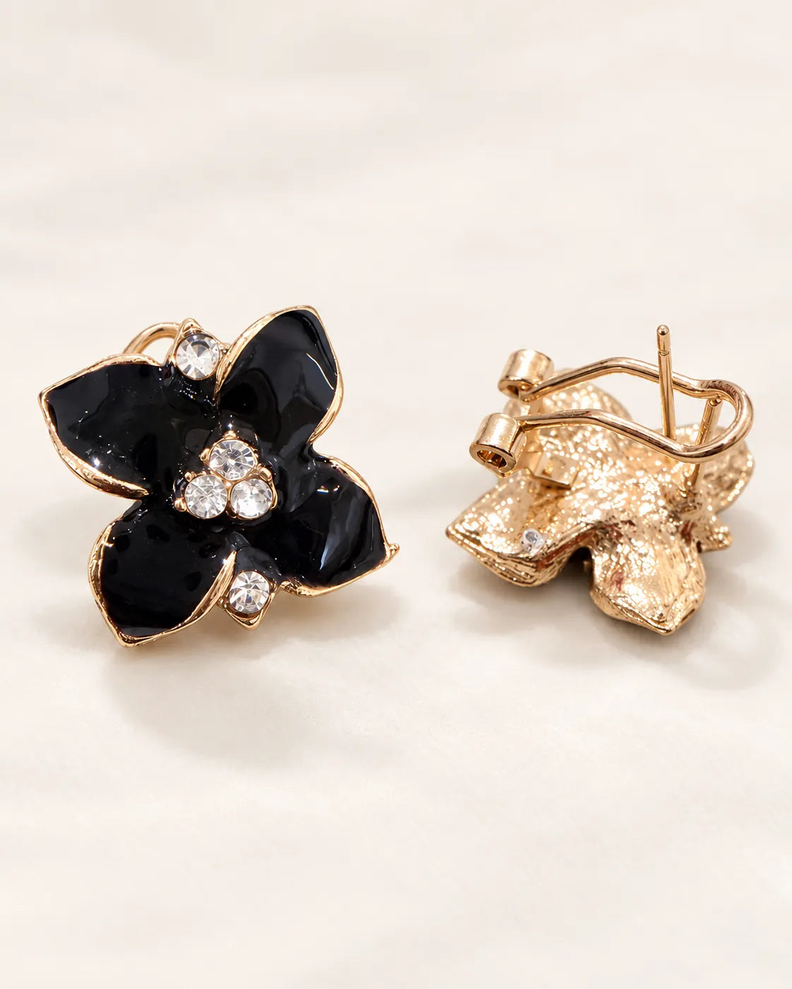Black camellia stud front beside its gold-tone clip-style back