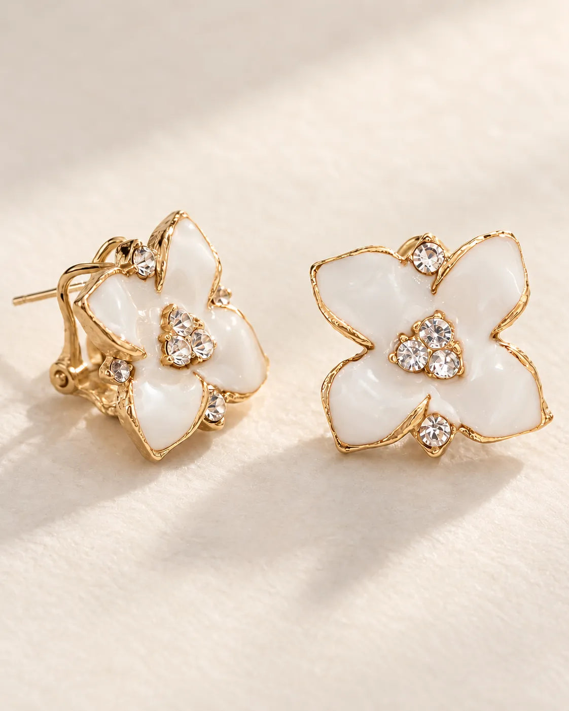 Angled pair of white camellia studs showing the clip-style lever back
