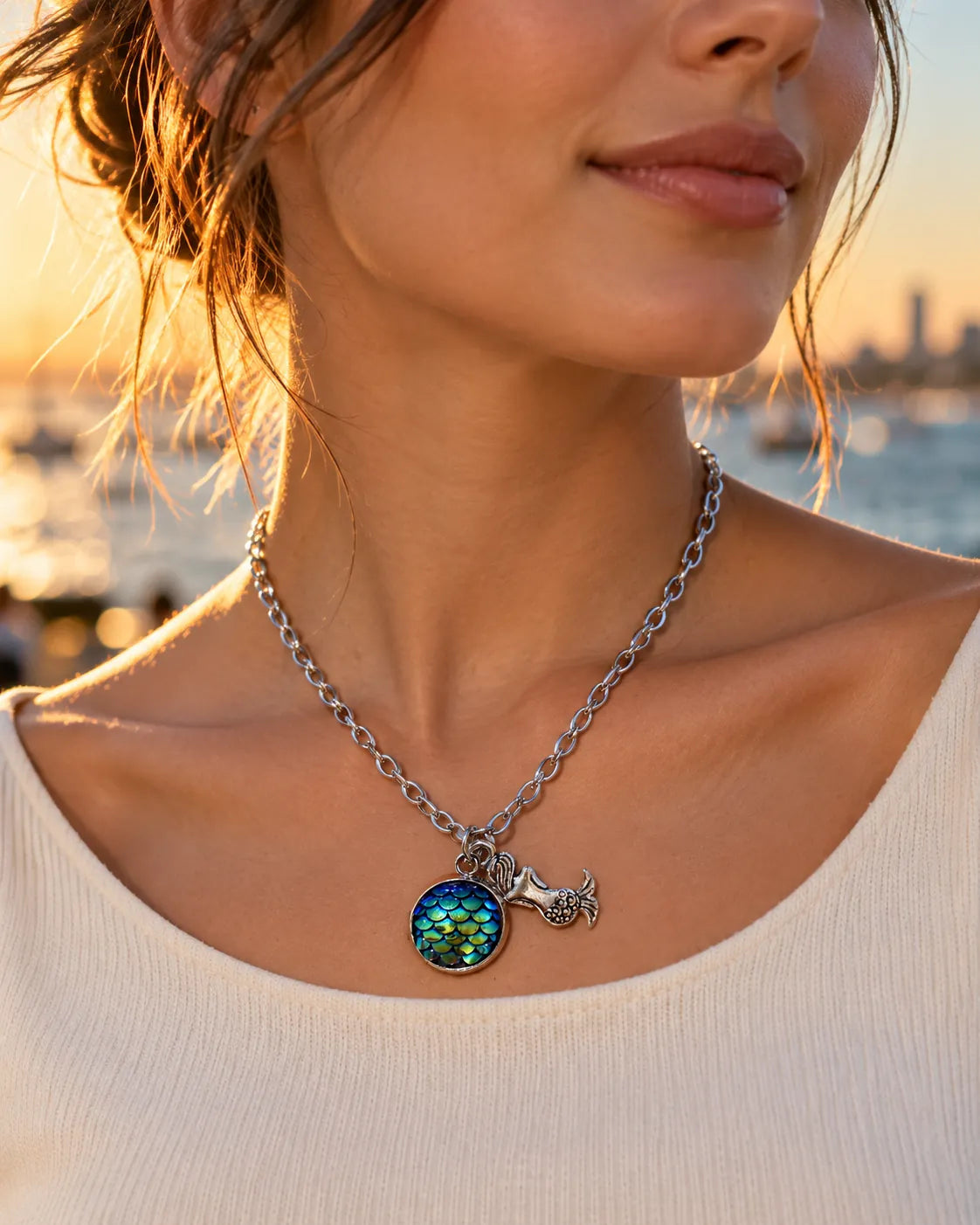 Model in a cream top at sunset wearing the silver mermaid scale necklace