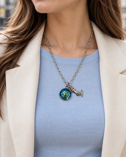 Model in a light blue top and cream blazer wearing the mermaid pendant