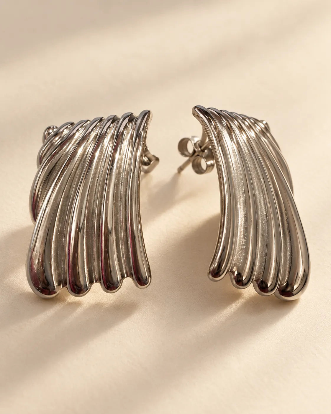 Angled pair of polished silver striped ribbed stud earrings