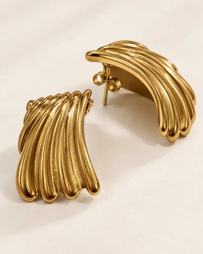 Side profile of the gold ribbed studs showing the outward wave curve