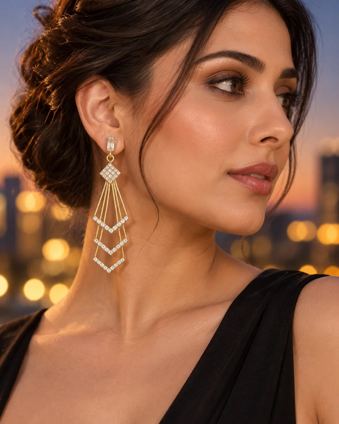 Model at dusk in a black top wearing the gold multi-layer drop earrings
