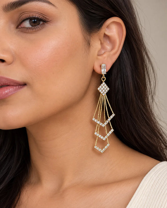 Close-up of the gold chevron tassel earring worn by a model