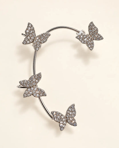Silver curved ear cuff with four pavé crystal butterflies on cream