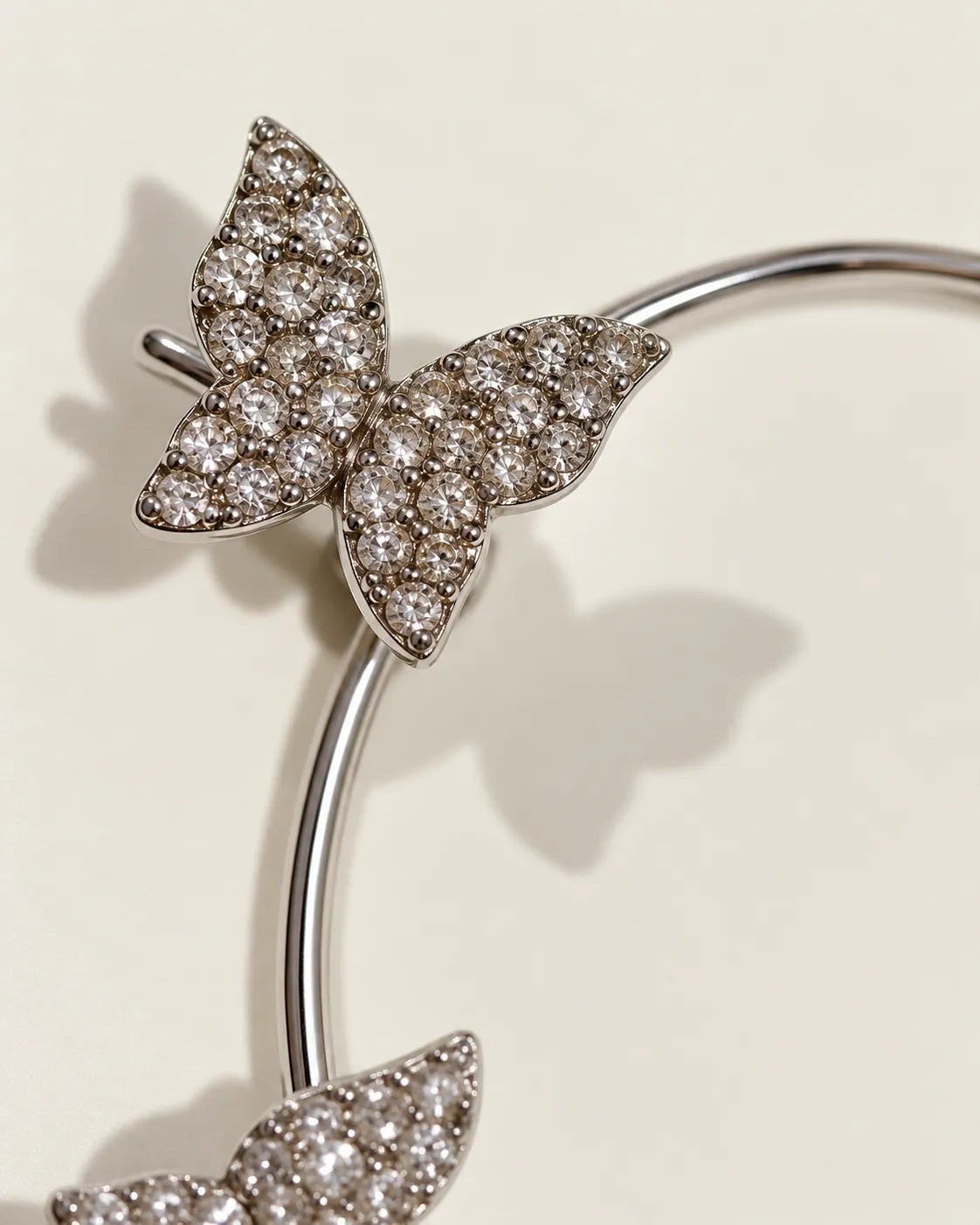 Close-up of a pavé crystal butterfly on the silver ear cuff