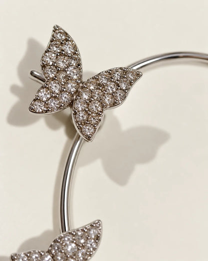Close-up of a pavé crystal butterfly on the silver ear cuff
