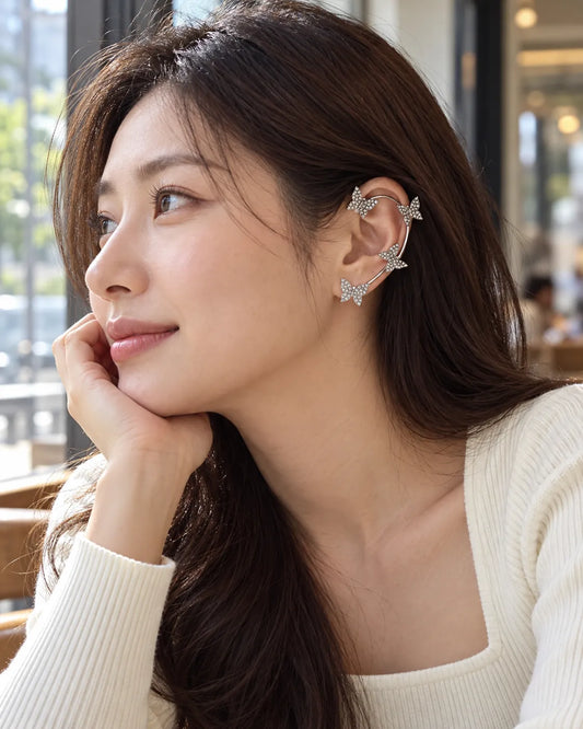 Model at a café wearing the silver butterfly clip-on ear cuff