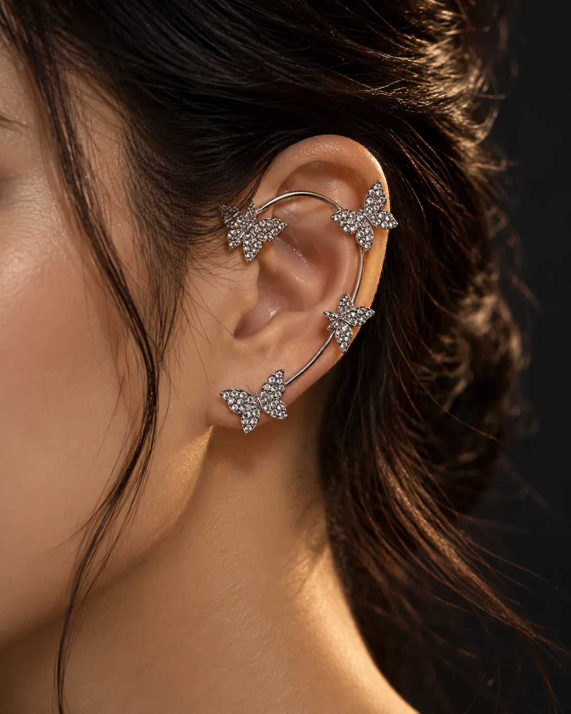 Close-up of the silver butterfly clip-on ear cuff worn up the ear